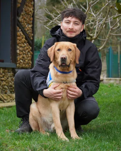 Photo de Kaelig avec son chien, un labrador de couleur sable