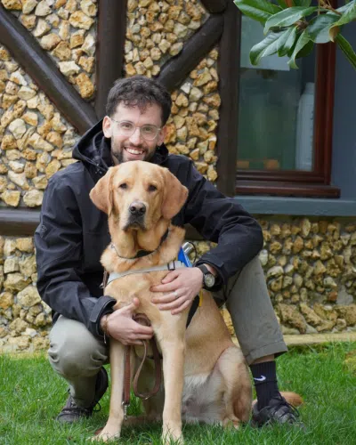 Photo de Lyes, moniteur à l'éducation avec son chien, un labrador de couleur sable