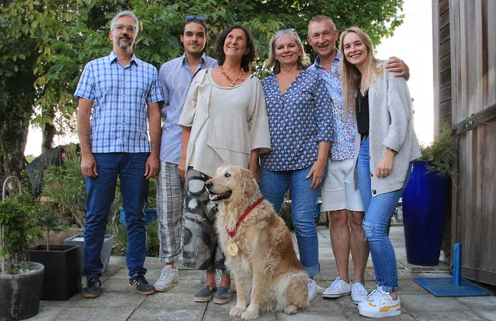 La famille Duchaussoy est réunie avec Delphine et Edel au milieu portant sa médaille de chien guide retraité