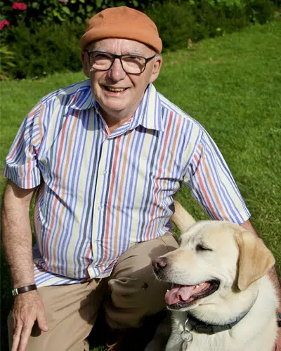 Bernard Nebot posant aux côtés d'un chien guide