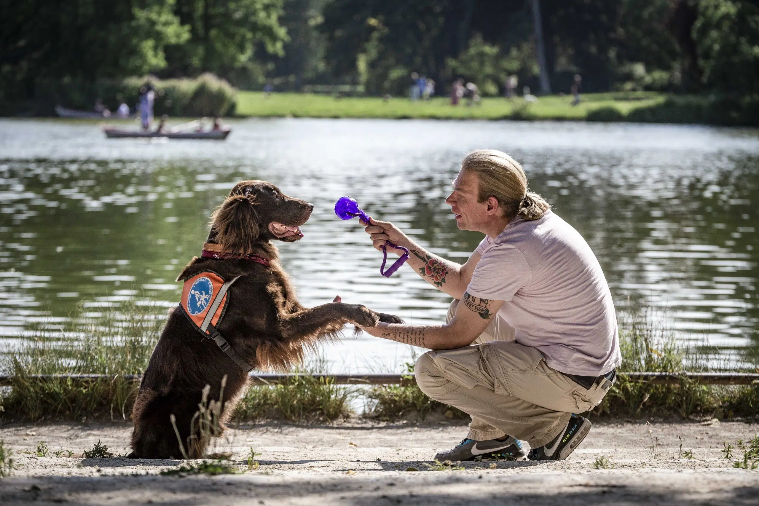 Olivier et son chien guide Orient, jouent devant le lac Daumesnil 