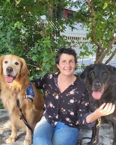 Catherine Pignal est assise avec deux chiens.