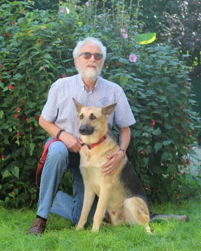 Michel est assis avec Païko son chien guide
