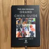 Livre de poche "Petit chiot deviendra grand chien guide". La couverture est noire, avec au centre plusieurs petits carrés contenant des photos de chiens guides.