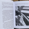 Photo d’illustration du livre : une page de texte accompagnée d’une page avec la photographie d’un chien portant son harnais de travail.