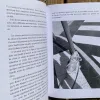 Photo d’illustration du livre : une page de texte accompagnée d’une page avec la photographie d’un chien portant son harnais de travail.