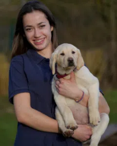 Amélie, avec un chiot beige dans les bras