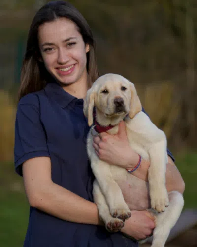 Amélie, avec un chiot beige dans les bras 