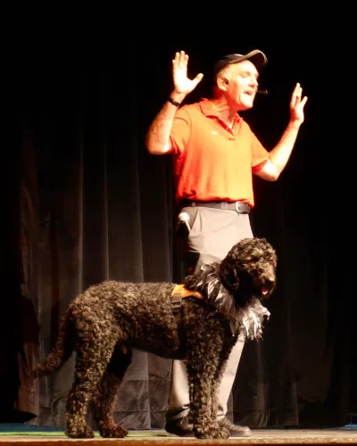 Photo de Norbert , un déficient visuel avec son chien guide Leroy, un labradoodle noir