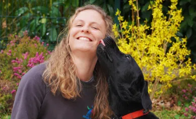 Lydie pose avec Uba qui lui lèche la joue