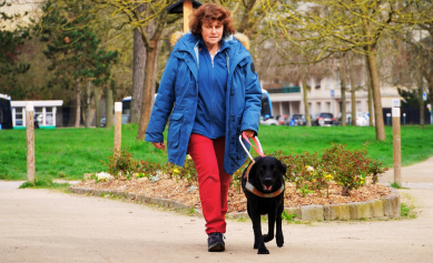 Marie-Hélène marche dans la rue guidée par Uba