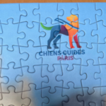 Photo du logo de l'Ecole de Chiens Guides de Paris sur le puzzle