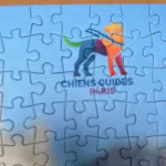 Photo du logo de l'Ecole de Chiens Guides de Paris sur le puzzle