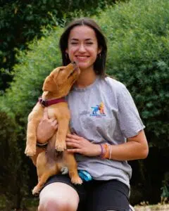 Amelie posant aux côtés d'un chiot