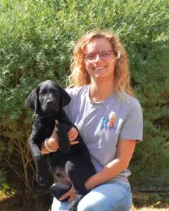 Cécile posant aux côtés d'un chiot