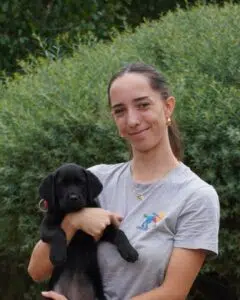 Zoé posant aux côtés d'un chiot